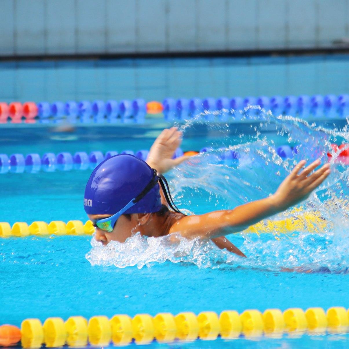 person in blue swimming goggles in swimming pool during daytime